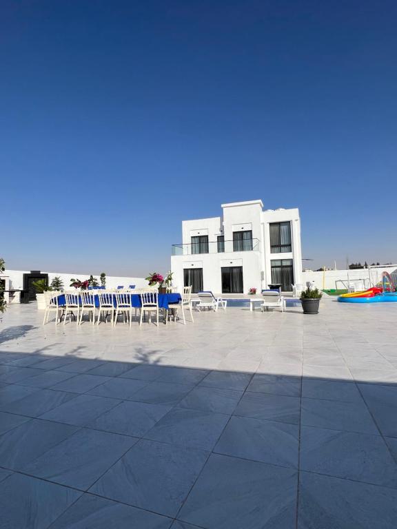 a patio with chairs and tables and a building at Amman villa in Amman