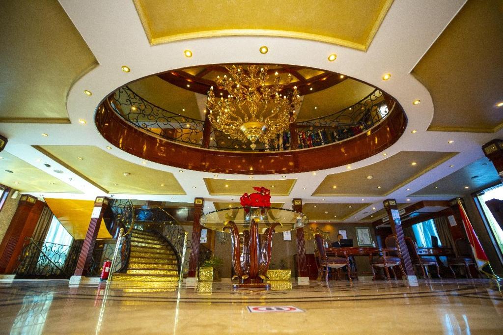 a lobby with a chandelier and stairs in a building at Bule Shadow III in Nag` el-Fuqâhi