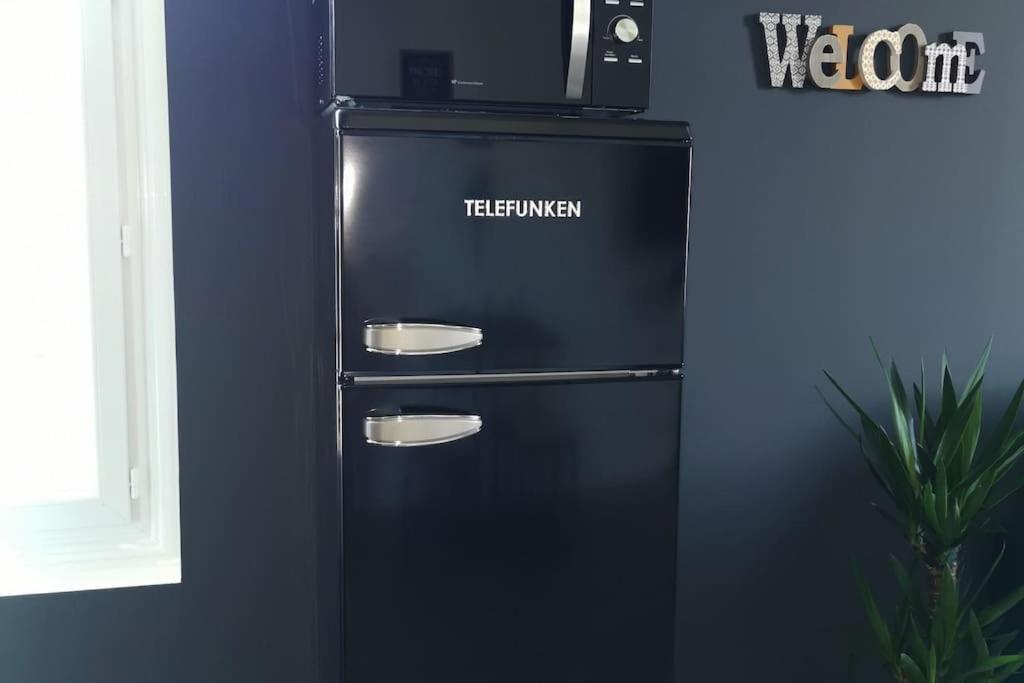 a black refrigerator with a microwave on top of it at LE MEDITERRANEEN *T2 (40m²) *WIFI*PARKING PRIVE* in Lourdes