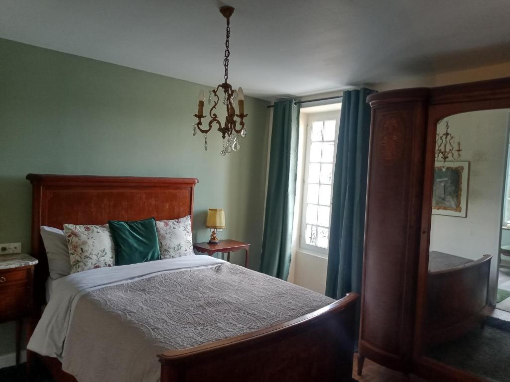 1 dormitorio con cama y lámpara de araña en Sept-Forges Gite, en Sept-Forges
