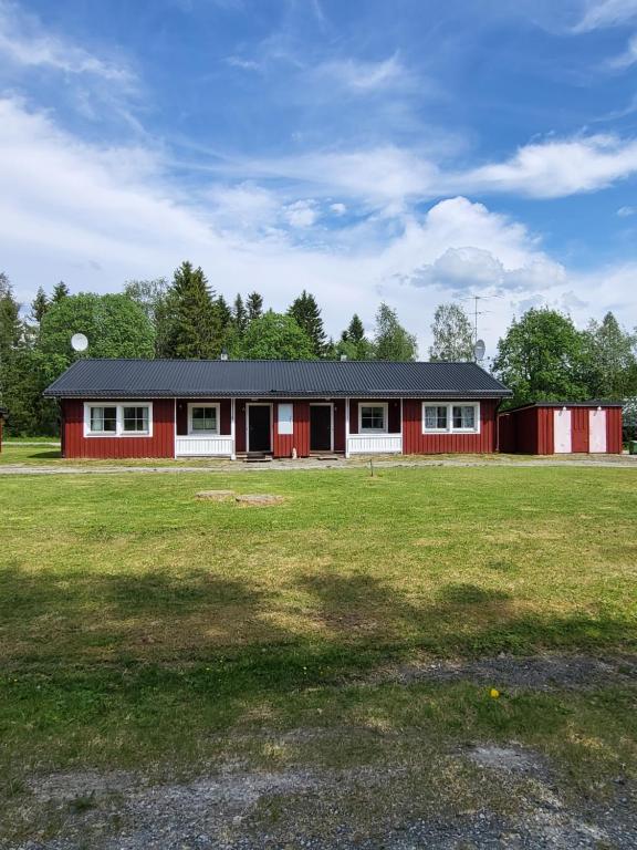 a red and white building in a field at Stugby Marieke - Skärvången in Föllinge