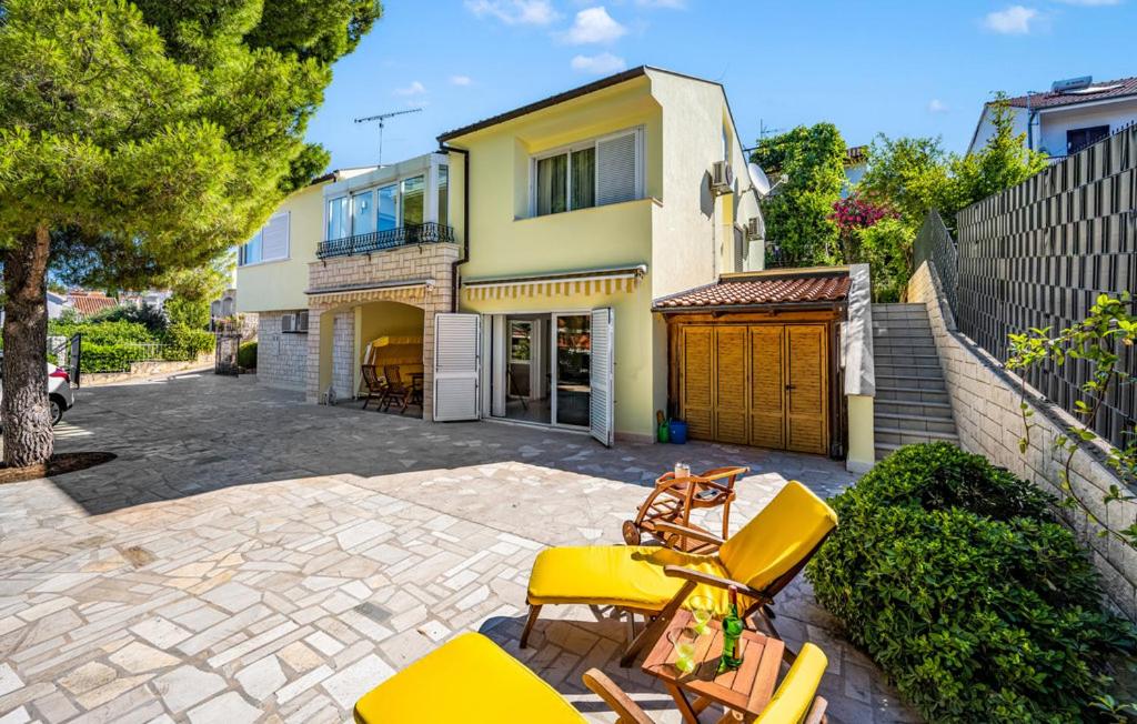 eine Terrasse mit gelben Stühlen und ein Haus in der Unterkunft VILLA M&M - sea and beach within 35 steps in Zaboric