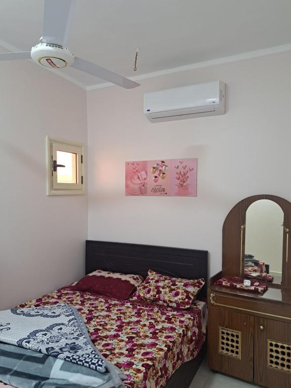 a bedroom with a bed and a dresser and a mirror at Sweet Home Flat 1 in Hurghada