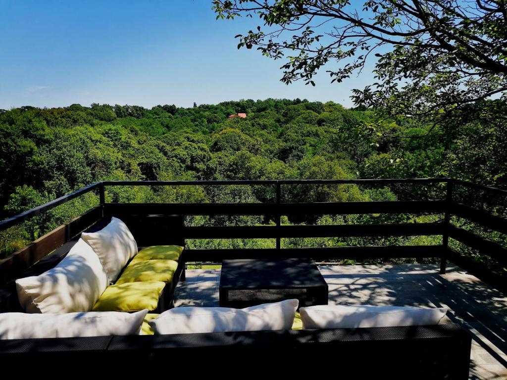 a balcony with pillows and a view of a forest at Greencajt in Jakopovec