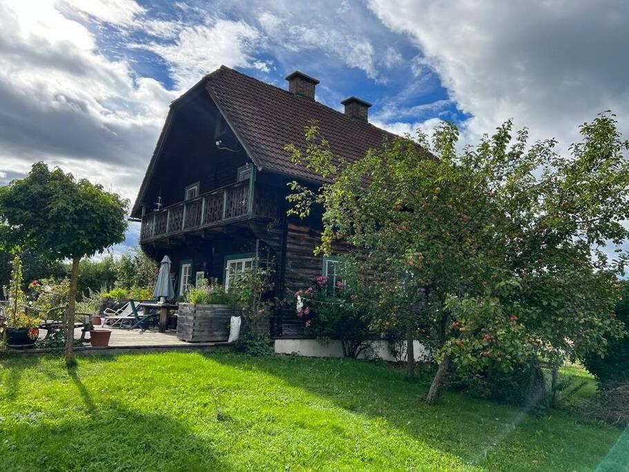 una casa de madera con un patio de césped y una casa en Ferienhaus Schlossbauer, en Spielberg