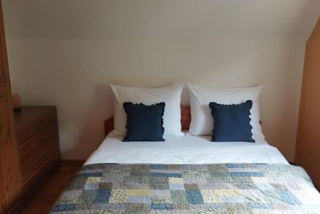 uma cama com duas almofadas azuis em cima em Ferienhaus Schlossbauer em Spielberg