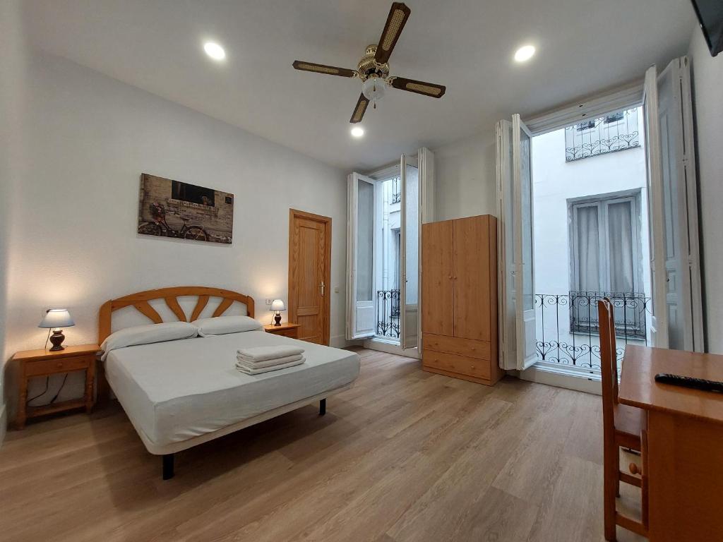 1 dormitorio con 1 cama y ventilador de techo en Hostal Miralva, en Madrid
