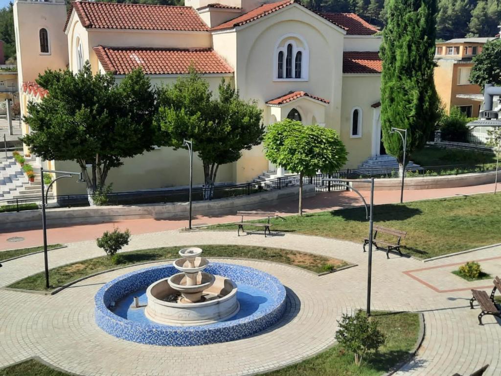 a fountain in a park in front of a building at Vila Lefteria in Këlcyrë