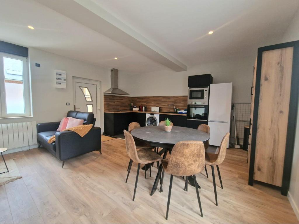 eine Küche und ein Wohnzimmer mit einem Tisch und Stühlen in der Unterkunft Maison T3 Mérignies in Mérignies