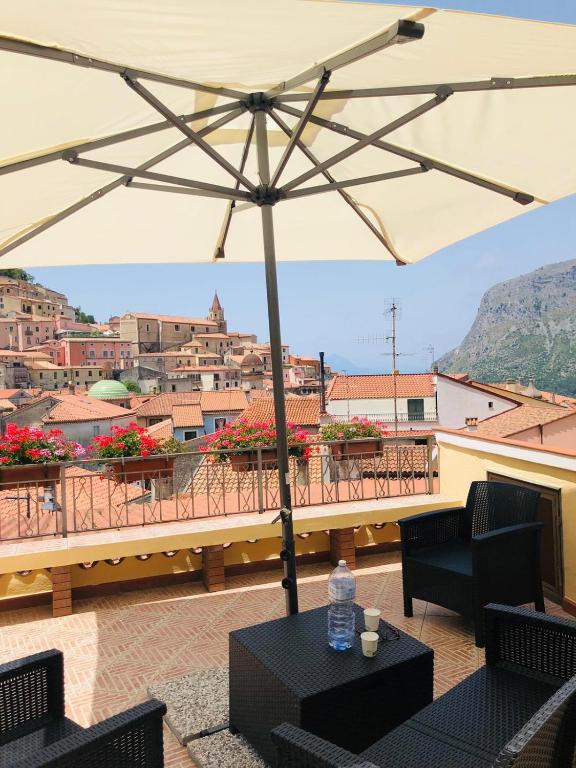 an umbrella on a balcony with a view of a city at Blasu Home in Maratea