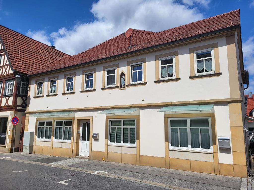 um grande edifício branco com um telhado vermelho em Ferienwohnung an der Eiswiese em Ebern