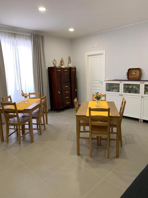 uma sala de jantar com duas mesas e cadeiras e uma cozinha em La Masseria di Felicetta em SantʼAnastasia
