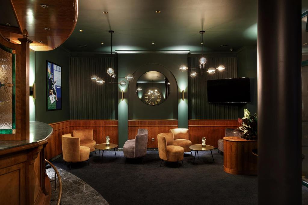 a bar with chairs and tables and a mirror at Hotel Nova in Berlin