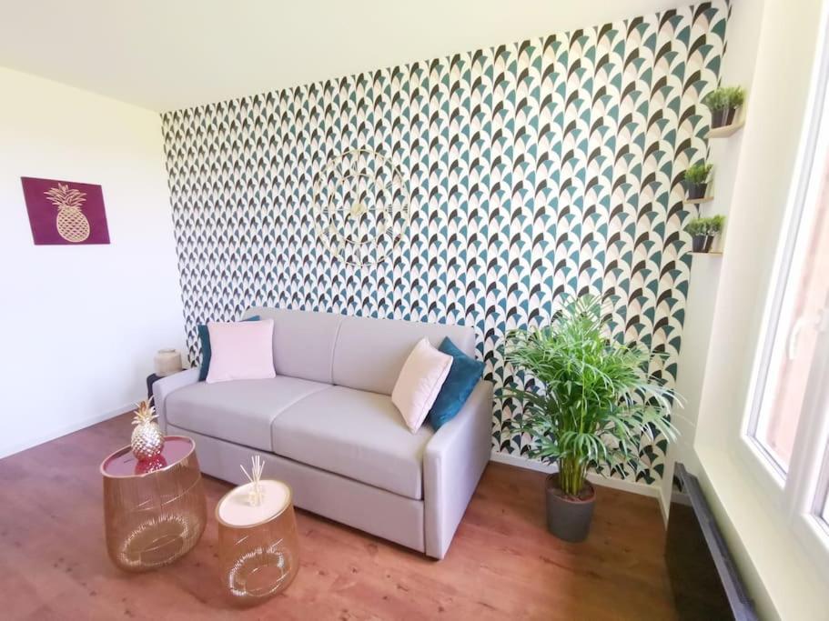 a living room with a couch and a patterned wall at LE GOURMAND *T2 (40m²) *WIFI*PARKING PRIVE*CALME in Lourdes