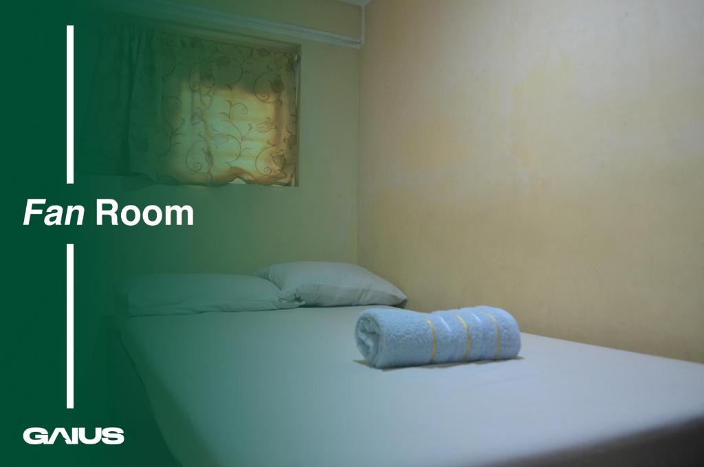 Una habitación con una cama con una toalla azul. en Gaius Inn, en Manila
