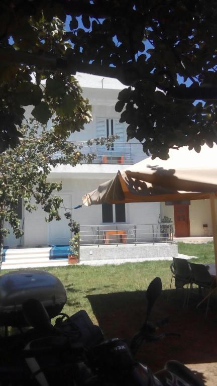a view of a building with an umbrella and chairs at Holiday Apartment in Draç