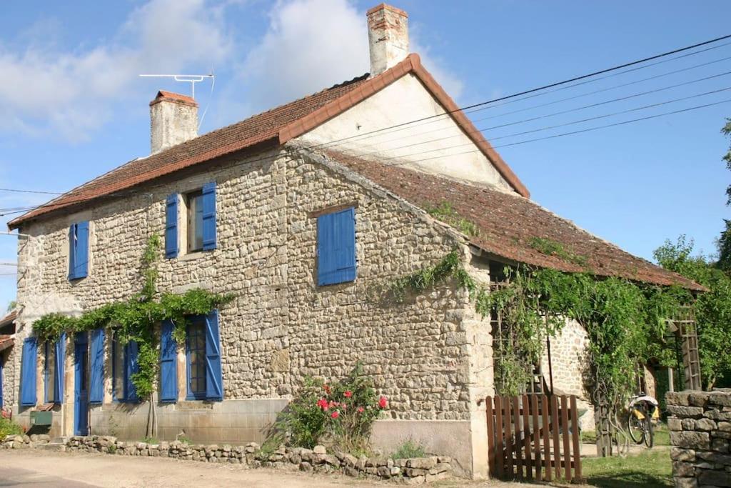 an old stone house with blue windows and a fence at Belle Maison en Bourgogne - Auxois - Morvan in Flée