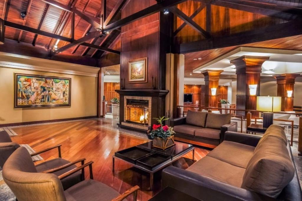 sala de estar con sofá y chimenea en Suíte 455 Wish Resort Gramado, en Gramado