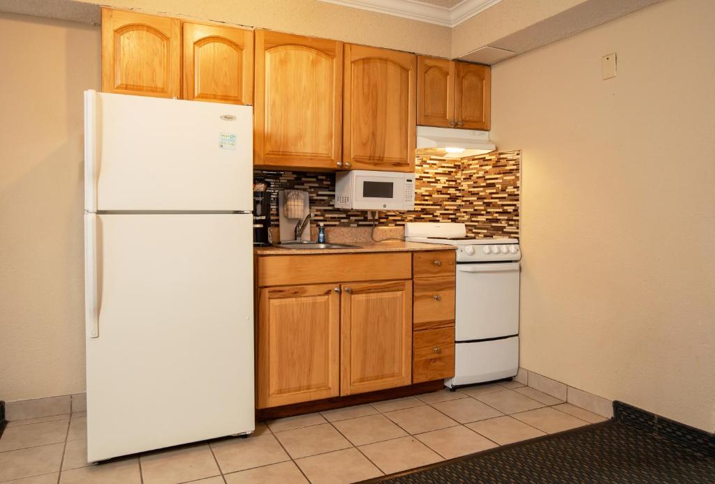 a kitchen with a white refrigerator and wooden cabinets at Grande Shores in Myrtle Beach