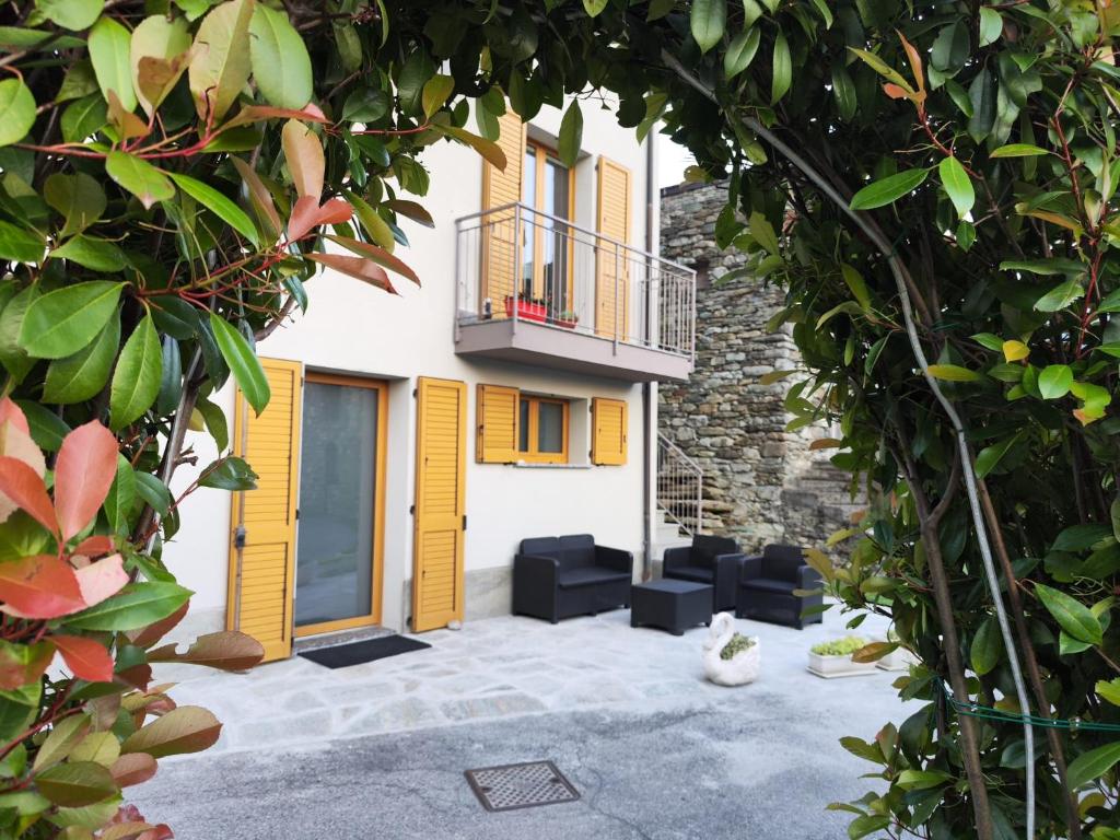 un cortile con sedie nere e un edificio di Casa Vacanza Relax Sondrio a Sondrio