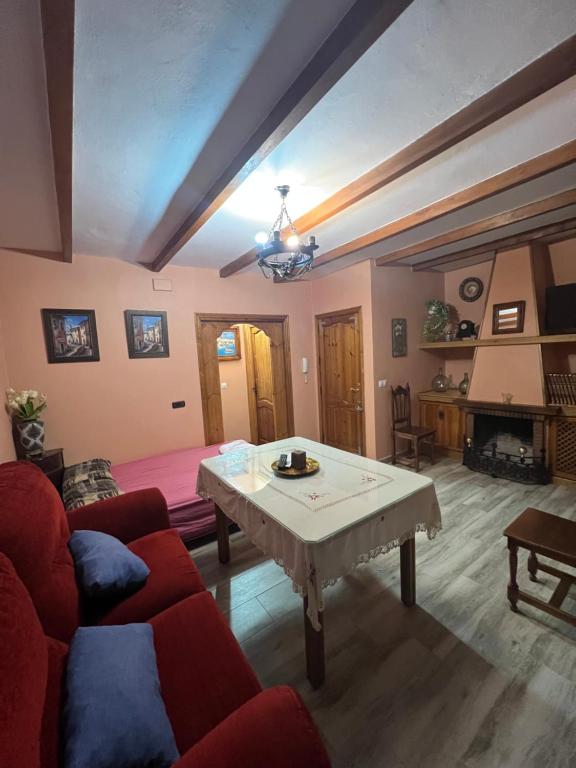 een woonkamer met een rode bank en een tafel bij Apartamento Cerro De Las Salinas in Ronda