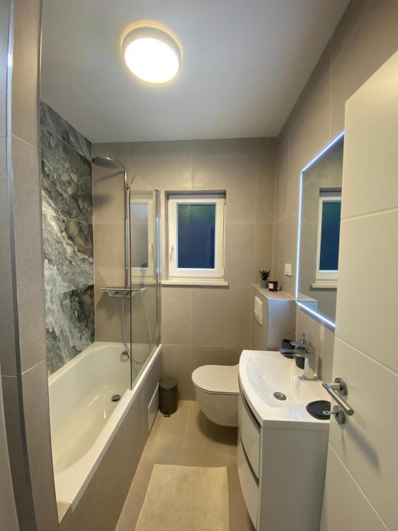 a bathroom with a sink and a toilet and a tub at Holiday home Maslina in Orebić