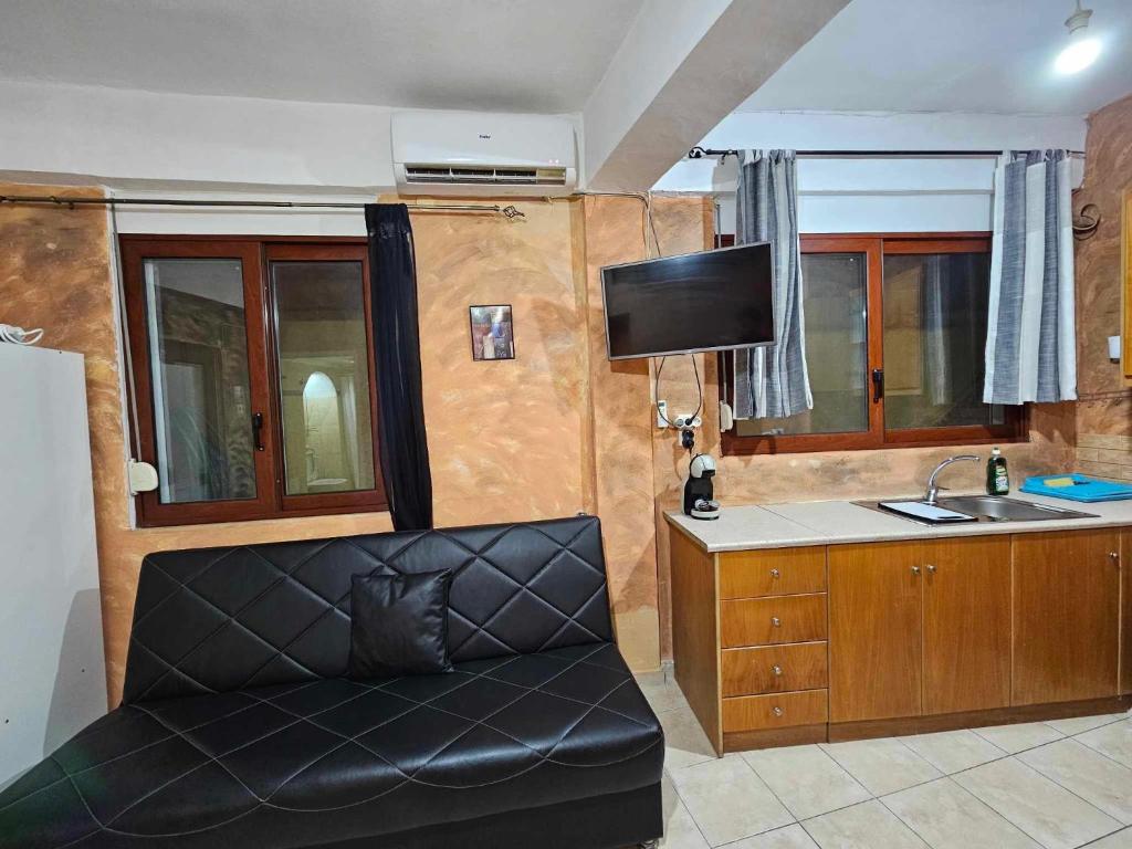 George's Guest House في مدينة خانيا: غرفة معيشة مع أريكة ومغسلة وتلفزيون