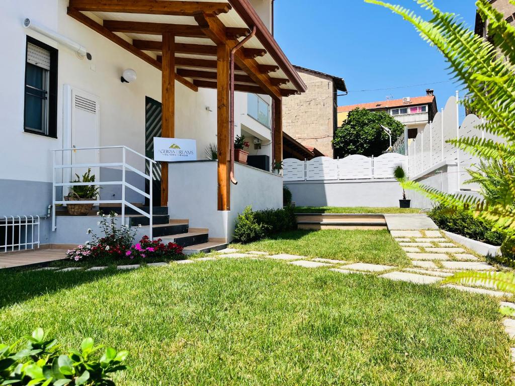 a house with a grass yard and a wooden pergola at Agerola Dreams in Agerola