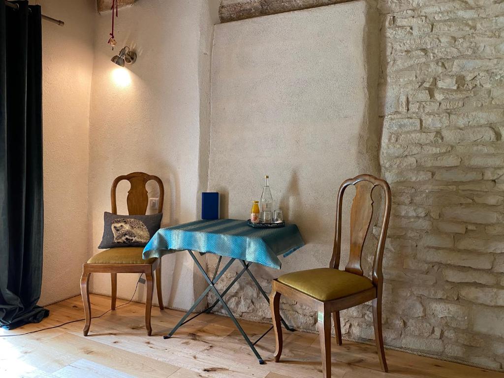 a table and two chairs in a room at Moulin de la Rouchotte in Frétigney-et-Velloreille