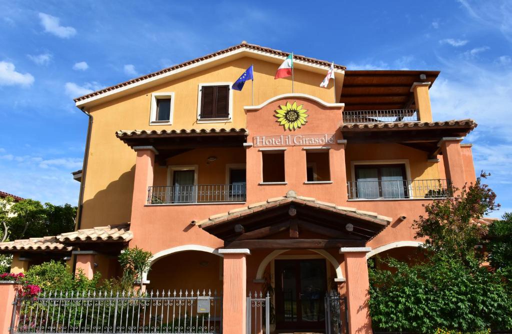 un bâtiment avec une horloge en haut dans l'établissement Hotel Il Girasole, à Villasimius