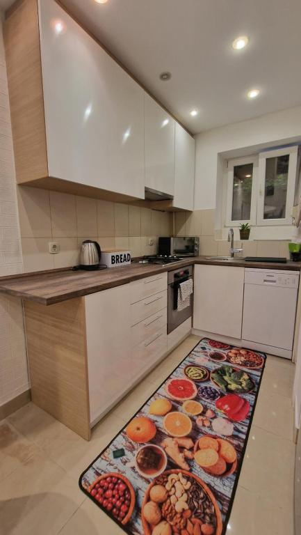 a kitchen with a table with food on a rug at Apartman Roses in Zagreb