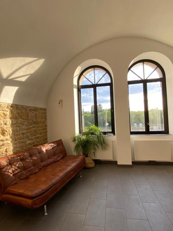 - un canapé en cuir dans une pièce avec trois fenêtres dans l'établissement Luxury Loft Metz, à Metz