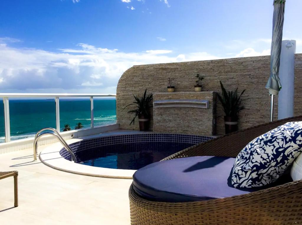a patio with a swimming pool and the ocean at Apartamento-Cobertura de Luxo Vista Mar em Salvador in Salvador