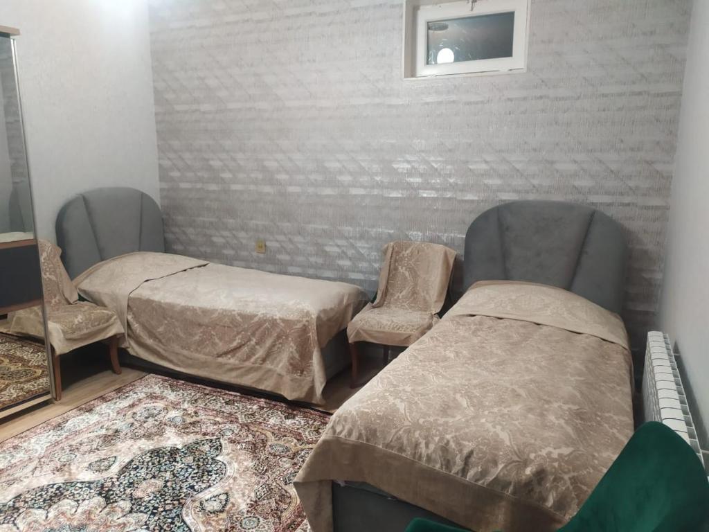 a room with two beds and a chair and a mirror at House in Nakhchivan city, Azerbaijan in Naxçıvan