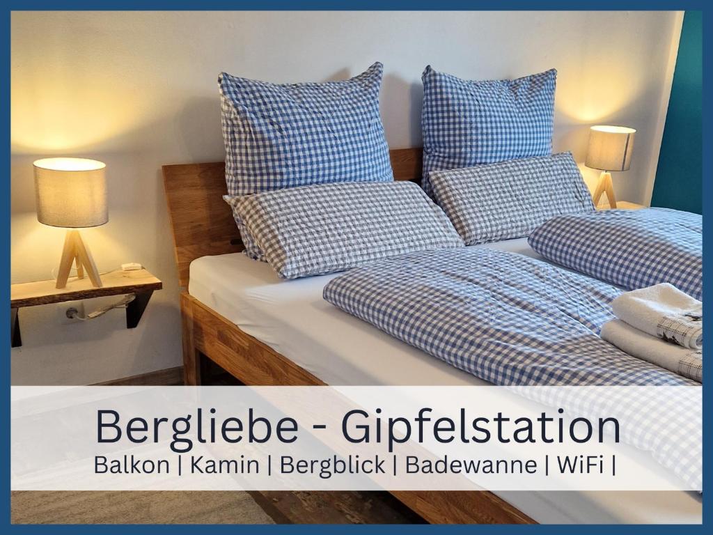 a bedroom with two beds with blue and white pillows at Bergliebe - Gipfelstation in Blaichach