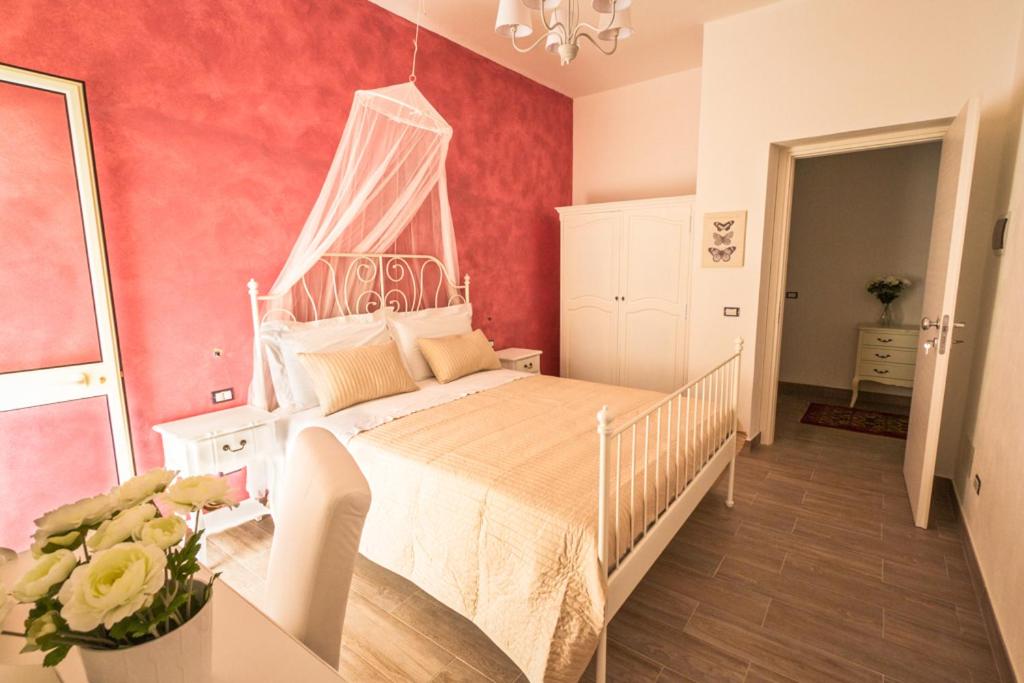 a bedroom with a white bed with a canopy at Venustas in Lampedusa