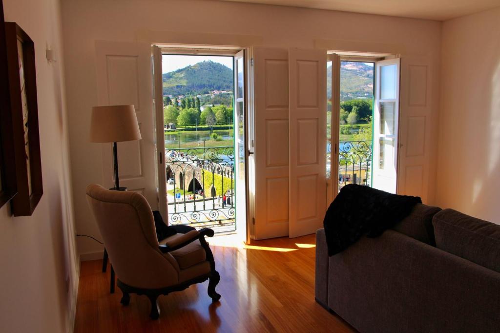 sala de estar con sofá, silla y ventana en Alma Da Vila en Ponte de Lima