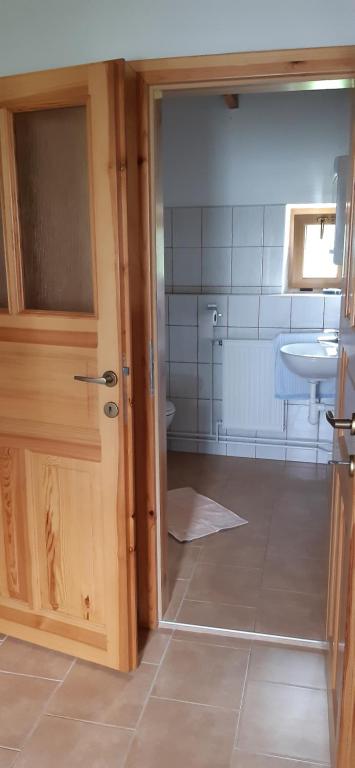 uma casa de banho com um WC, um lavatório e uma porta em Chata Gerlinda em Kašperské Hory