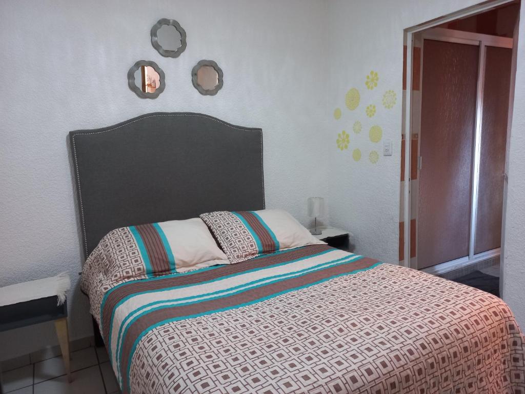 - une chambre avec un lit et deux miroirs sur le mur dans l'établissement Beautiful apartment. 5 minutos Aeropuerto Internacional de la Ciudad de México, à Mexico
