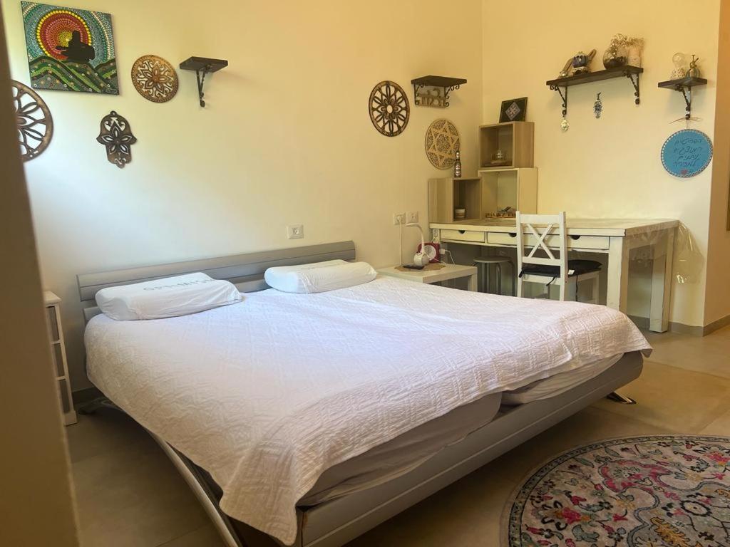 a bedroom with a large bed and a desk at נקודות ריפוי in Tirat Karmel