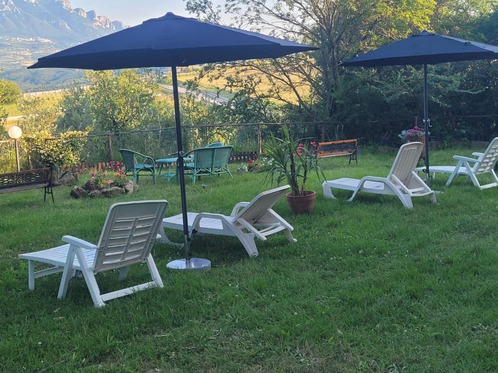 un grupo de sillas y una sombrilla en el césped en Villa Italia2 en Contursi