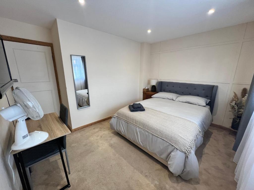 1 dormitorio con 1 cama y 1 mesa con lámpara en Beautiful Room for ONE Person - free Netflix, Amazon Prime & Disney plus, en Bromley