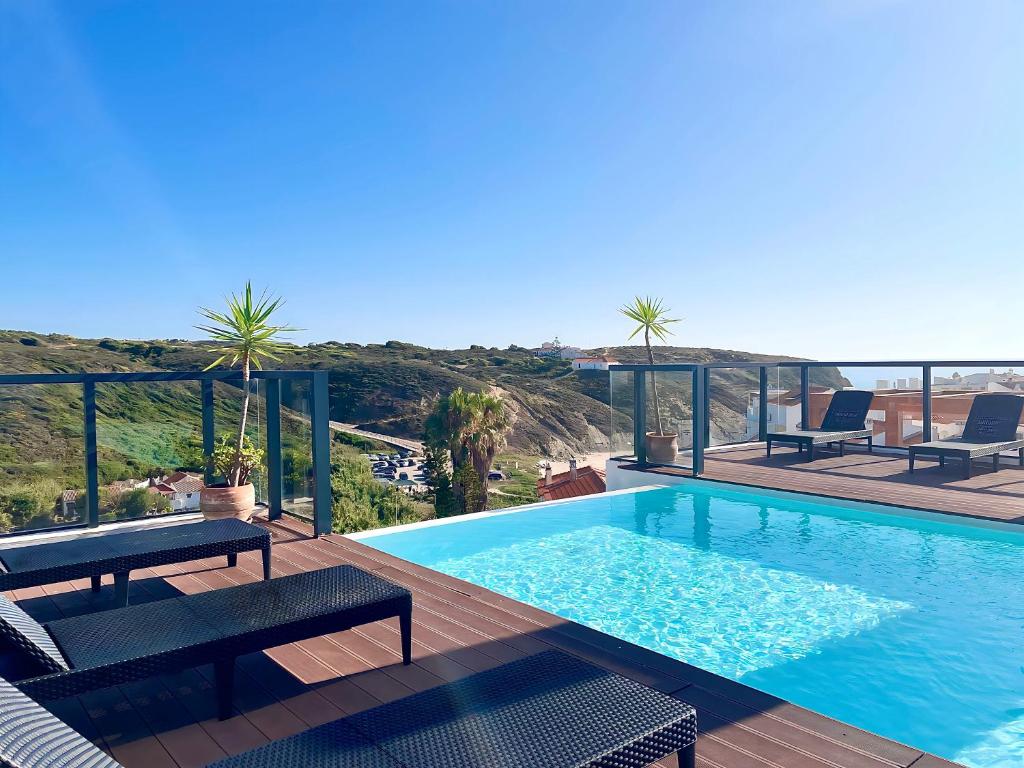 a swimming pool on a deck with a view of the ocean at Zambujeira Terrace in Zambujeira do Mar