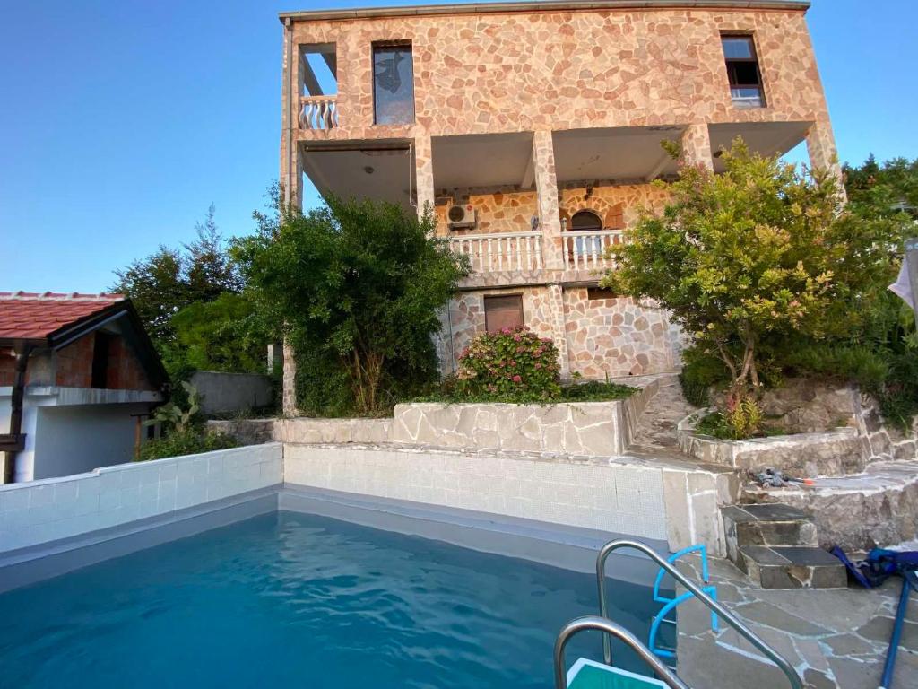 ein Haus mit einem Pool vor einem Gebäude in der Unterkunft Flower villa in Tivat