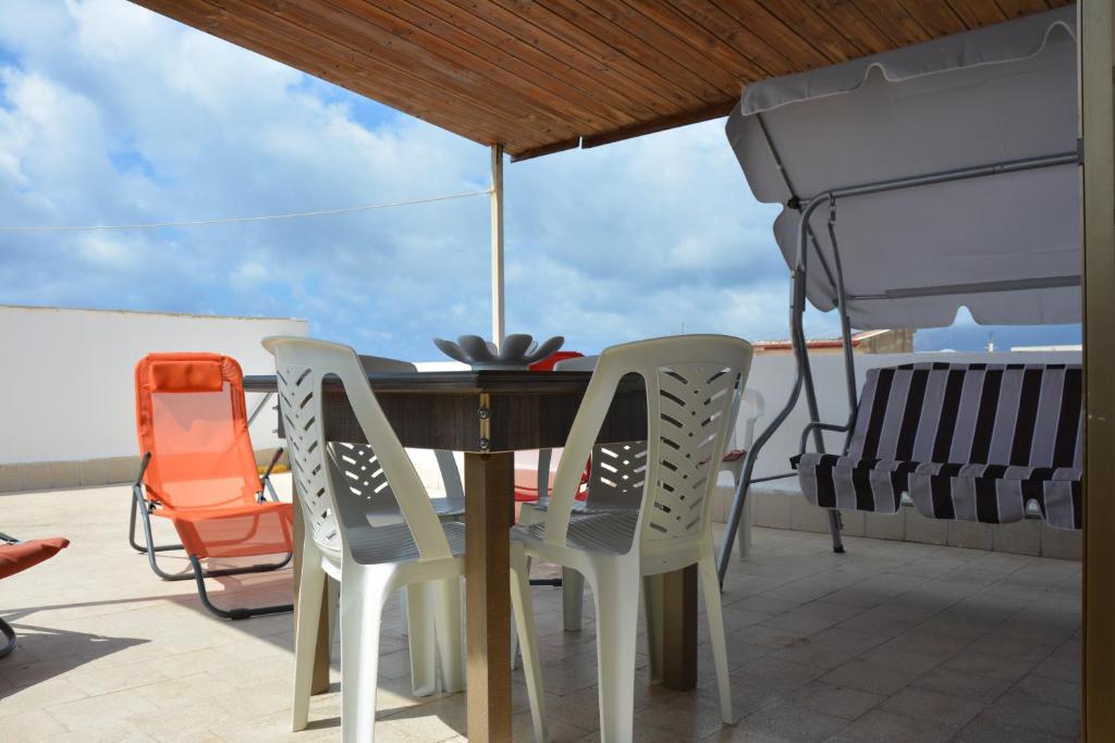 a table with chairs and an umbrella on a patio at Case Vacanza Trappetodavivere in Trappeto