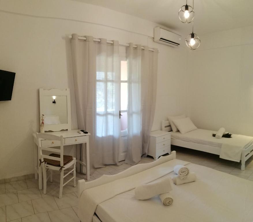 uma sala de estar branca com uma cama e um espelho em Pericles Apartment em Dassia
