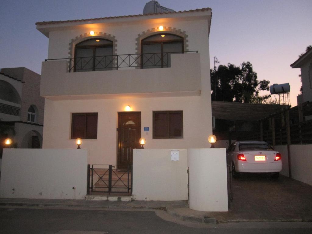 a white house with a car parked in front of it at Paradiso Villa in Protaras