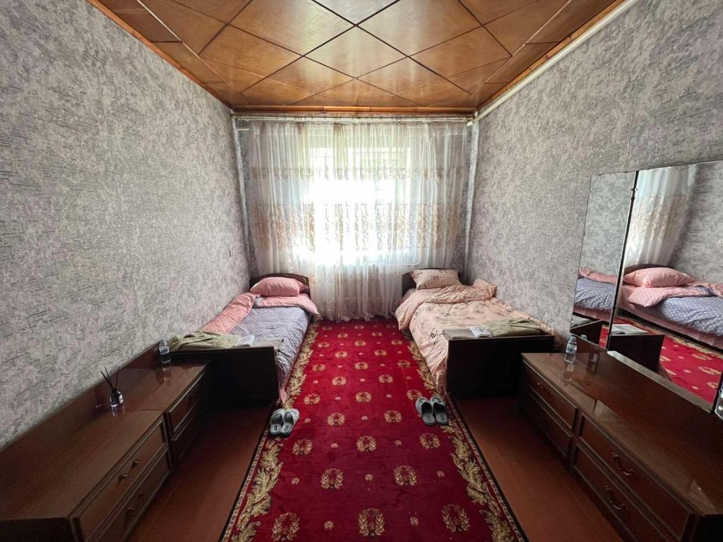 a small room with two beds and a red carpet at Гостевой дом in Ciorescu