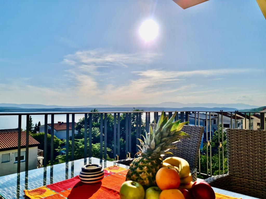 a plate of fruit on a table on a balcony at Apartments Sunflower in Dramalj