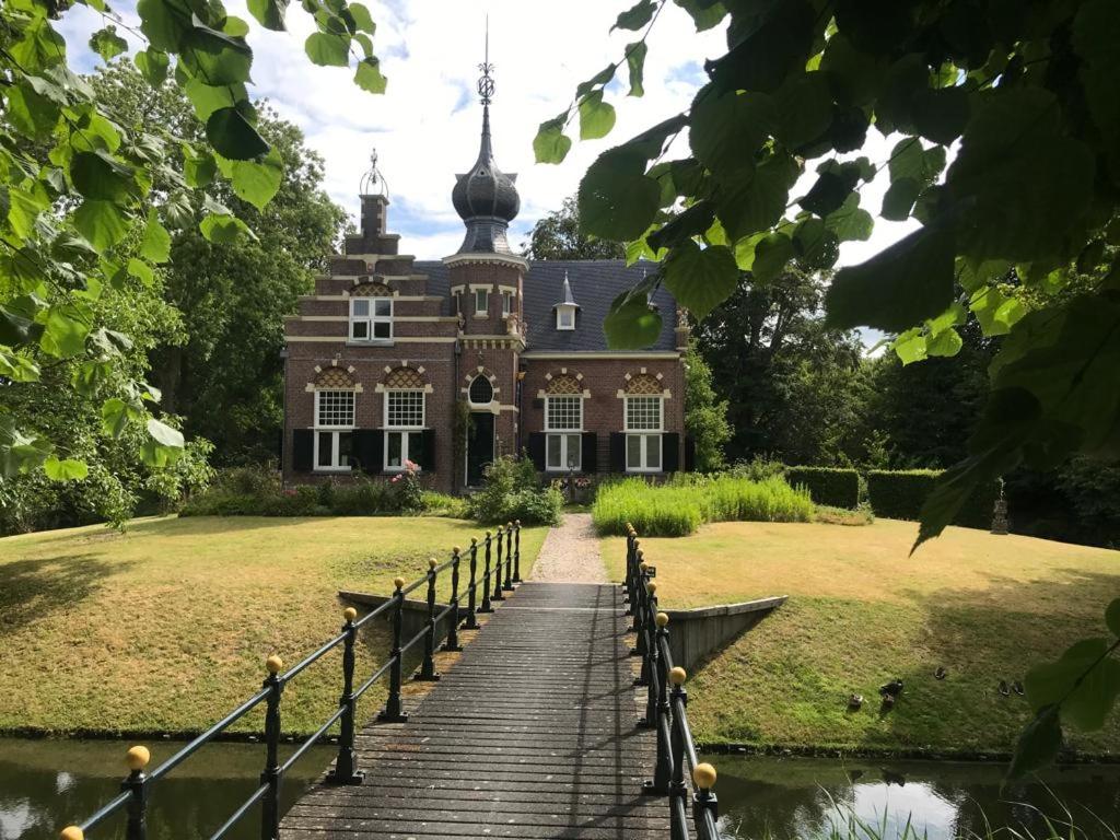 a large house with a staircase leading up to it at Bed and Breakfast Stinzenflora in Cornjum